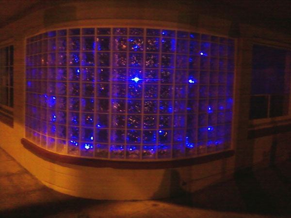 Curved glass-block wall lit from behind in blue.